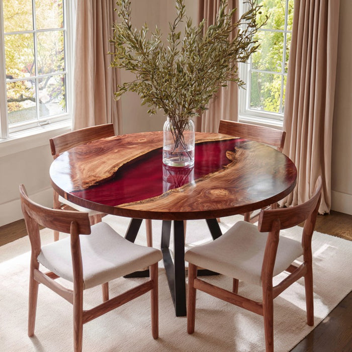 Dining room with a round wooden table and chairs, featuring a vase with greenery.