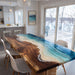 Artistic walnut epoxy table showcasing ocean-blue resin, flowing waves, and a smooth sand beach pattern.