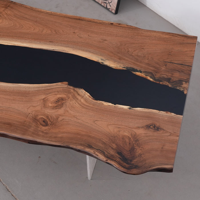 Wooden table with black resin inlay on a gray floor