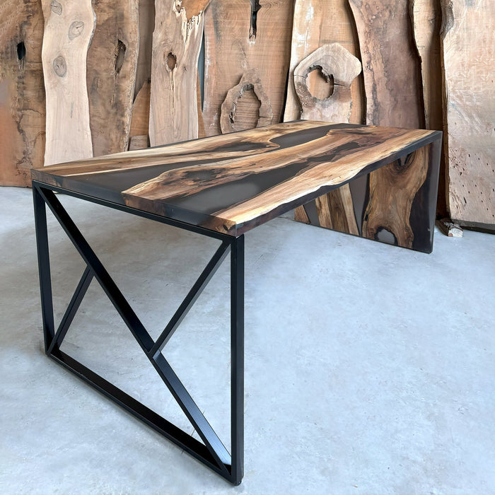 Wooden table with black metal legs against a wooden wall.