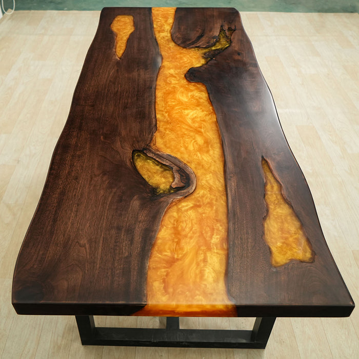 op view of a glowing LED walnut epoxy resin river table with amber tones.