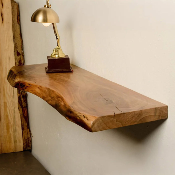 Wooden shelf with a gold lamp on a white wall