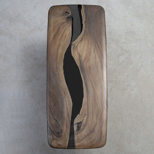 Handcrafted dining table featuring a solid wood slab and deep black epoxy river, blending rustic charm with minimalist modern aesthetics for luxury home decor.