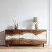 Wooden sideboard with white interior against a white wall