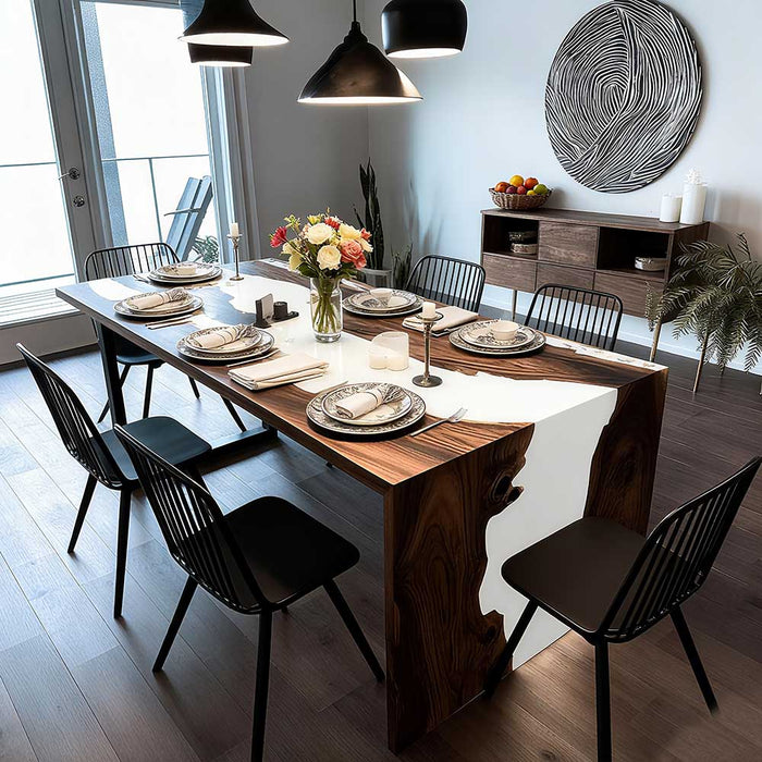 Dining room with a wooden table set for a meal, surrounded by black chairs.