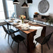 Dining room with a wooden table set for a meal, surrounded by black chairs.