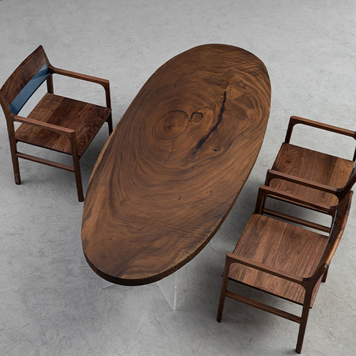 Elliptical walnut wood table crafted from a natural slab with rich grain patterns.