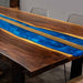 Dining table with wooden finish and blue resin inlay