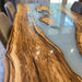 Close-up detail of white resin river flowing through premium olive wood slab table surface