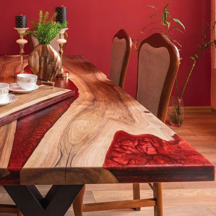 Wooden dining table with red accents in a room with red walls.