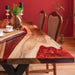 Wooden dining table with red accents in a room with red walls.