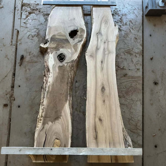 Two wooden slabs on a workbench with visible grain and texture.