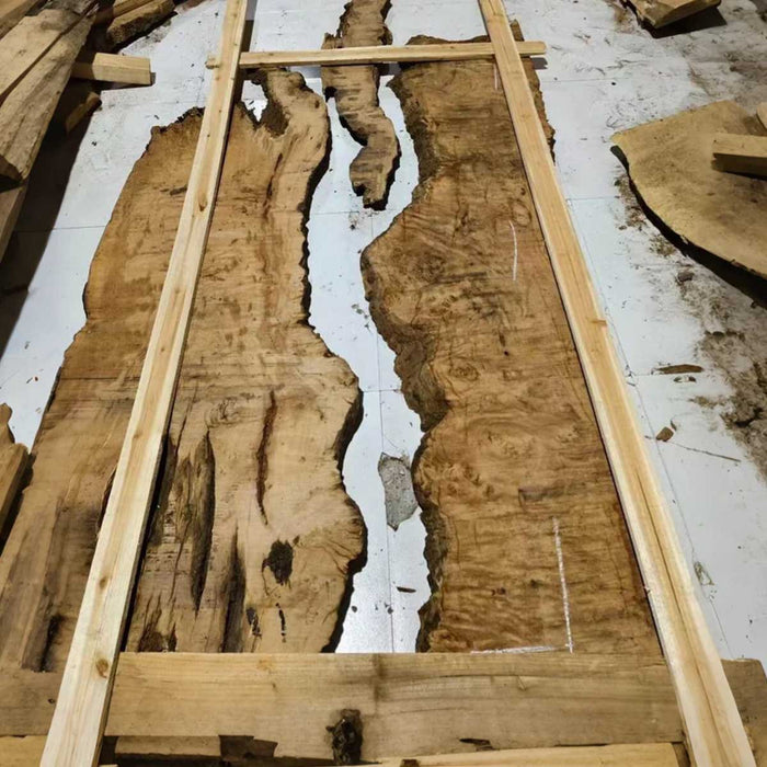 Wooden slabs with a natural, rough texture on a white floor.