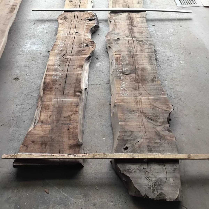 Two large wooden slabs with a natural, rough texture on a concrete floor.