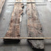 Two large wooden slabs with a natural, rough texture on a concrete floor.