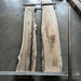 Two large wooden slabs with natural grain patterns on a concrete floor.